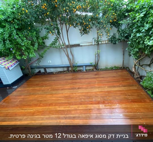 דק עץ בגינה עם עצים ושיחים מסביב